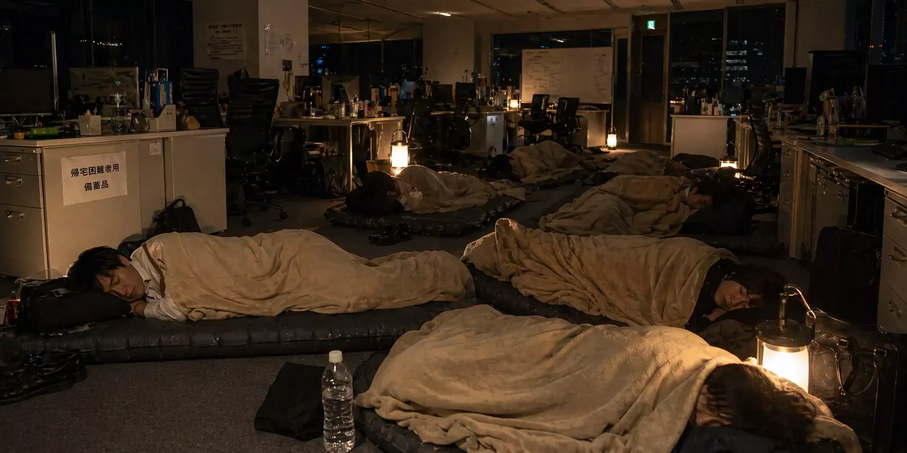 オフィスで防災マットを使い仮眠する社員